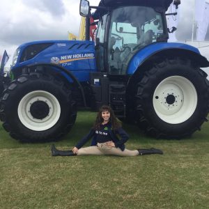 promotional girl does the splits in front of tractor